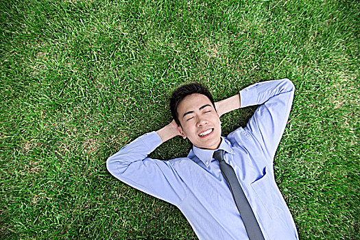 躺在草地上的商务男士