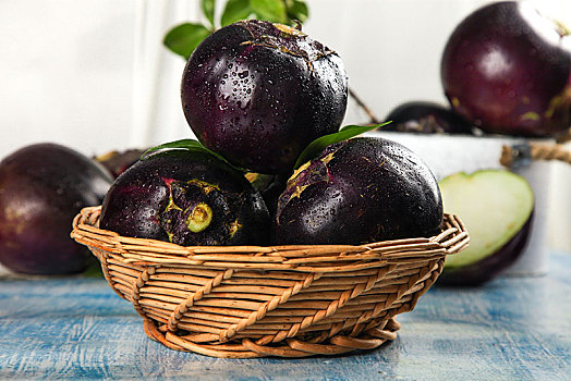 蓝底上放着一筐紫圆茄子