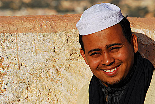 algeria,ben,isguen,portrait,of,a,smiling,young,man,wearing,skull,cap