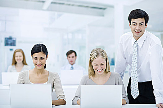 经理,站立,旁侧,雇员,工作,笔记本电脑,看镜头,微笑
