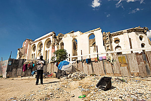 haiti,port,au,prince,father,with,baby,in,front,of,our,lady,the,assumption,cathedral,destroyed,and,ruin,after,earthquake