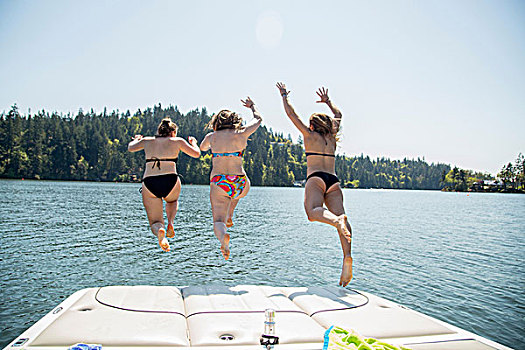 后视图,三个女人,年轻,跳跃,码头,湖,俄勒冈,美国