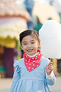 小女孩在游乐园吃棉花糖