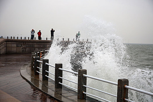 山东省日照市,灯塔风景区风大浪高,游客冒雨观赏浊浪排空奇观