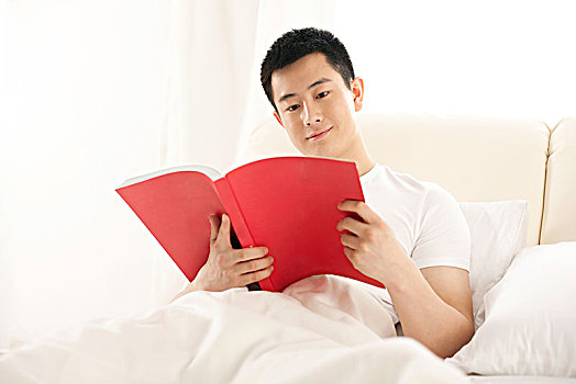 青年男子在床上看书