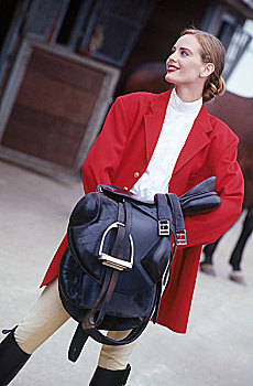 时尚,女人,骑马裤,红色,外套,拿着,马鞍,看别处,微笑