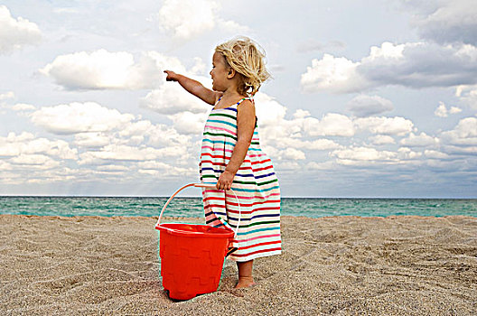 女孩,拿着,沙桶,海滩,指向,海洋