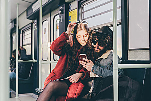 年轻,情侣,坐,地铁,看,智能手机