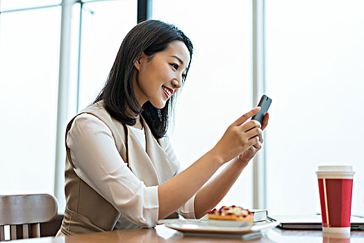 年轻女子在餐厅使用手机