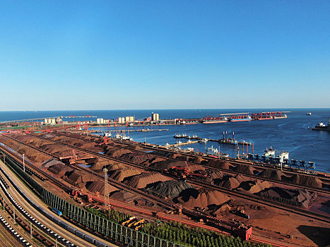 山东省日照市,蓝天下的港口装卸生产现场,货物错落有致生产繁忙有序