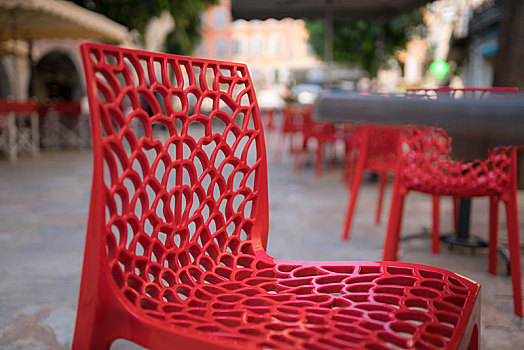 广场上镂空的红色塑料椅子