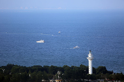 山东省日照市,蓝天白云下的海龙湾碧波万顷,游客乘坐游轮感受大海风情