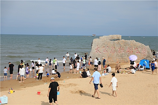 山东省日照市,太公岛游人如织,赶海拾贝做游戏乐在其中