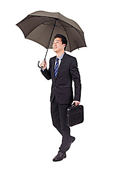 一个打着黑色雨伞手拿公文包的青年商务男士