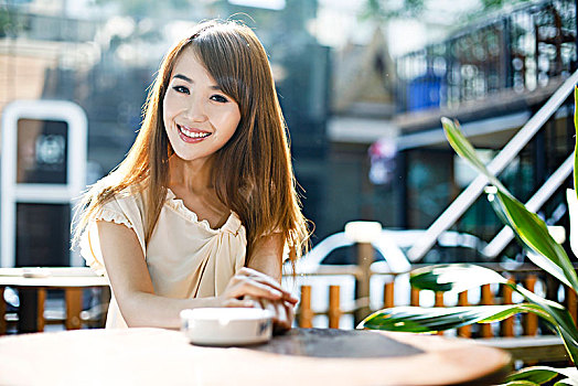 年轻女性在露天咖啡厅喝咖啡