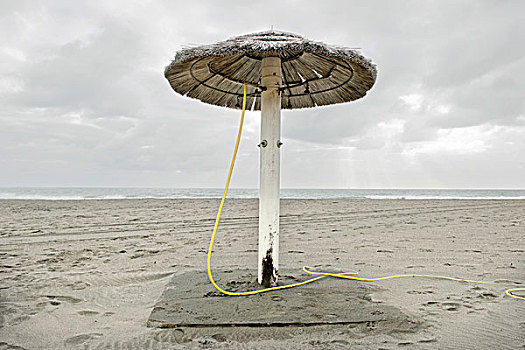 伞在海滩,在冬季,在一个多云的日子,奥斯蒂亚,丽都,罗马,意大利