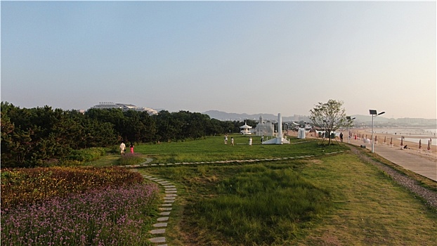 山东省日照市,雨后的海边环境宜人,游客赶海拾贝拍照打卡