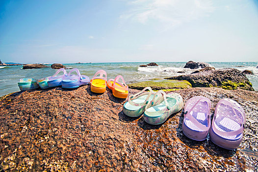 海边礁石上的一排凉鞋