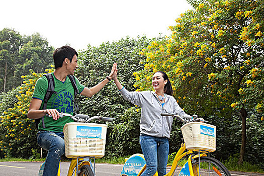 年轻大学生在校园里骑车