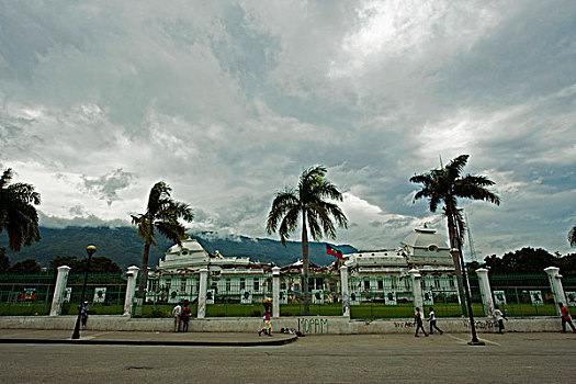 haiti,port,au,prince,people,walking,in,front,of,presidential,palace,with,photo,exhibtion,19,new,candidates