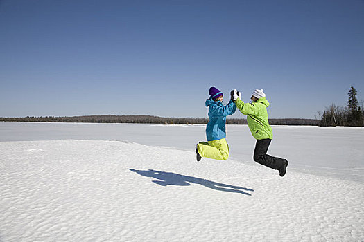 两个女人,跳跃,冰湖