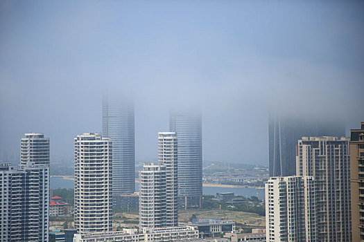 山东省日照市,夏季天气多变,站在百米高楼看云雾里的城市建筑