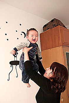 一名7个月大的男婴被母亲举高