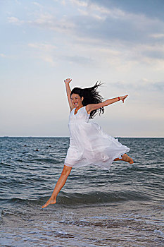 一位美女在海边跳跃