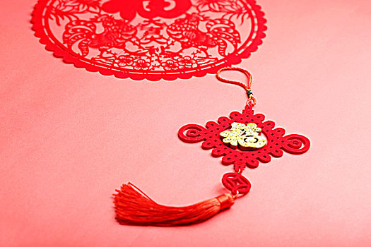 中国结和鸡年剪纸放在红色背景上