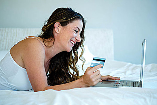 女人,电脑,拿着,信用卡,微笑,躺下,笔记本电脑