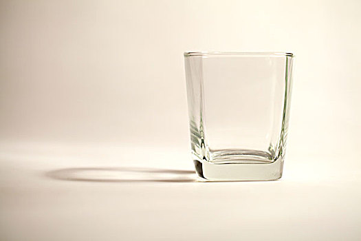 白光下透明的方口玻璃杯和它的倒影