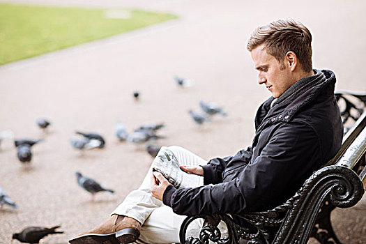 男青年,坐,公园长椅,读报