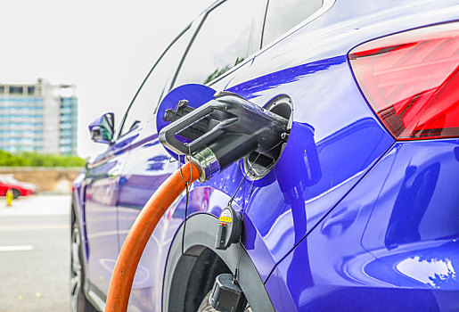新能源汽车充电站正在充电的汽车和充电枪特写