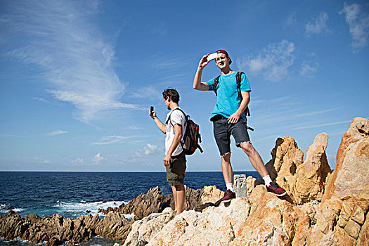 男青年,站立,石头,智能手机,拿,摄影,哥斯达黎加,萨丁尼亚,意大利