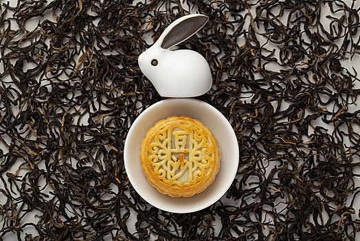 摆放在茶叶上的中秋月饼和月兔