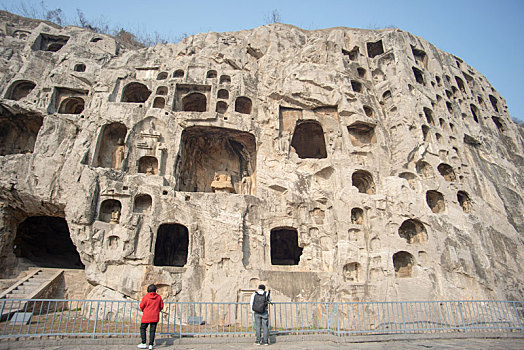 两个游客观看龙门石窟的洞穴雕刻