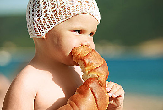 高兴,小,白人婴儿,吃,牛角面包,海滩