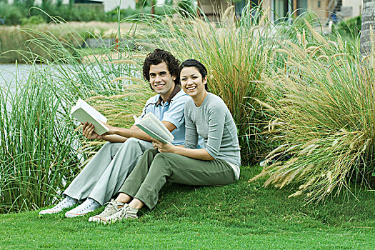 坐,夫妇,草地,书本,看镜头,微笑