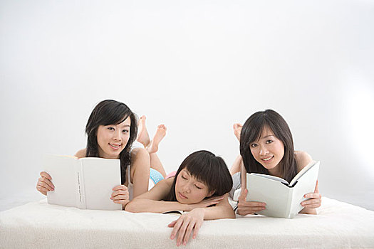 一起趴着看书的三个女人