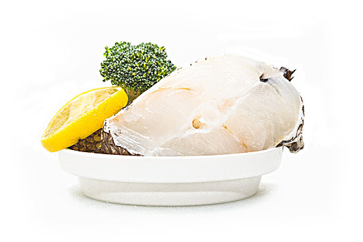 新鲜的生鳕鱼块摆放在白色的盘子里