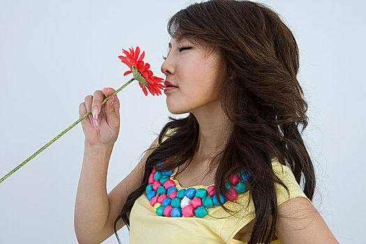 一个年轻漂亮的女人拿着花对着镜头摆姿势