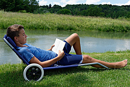 男孩,卧,折叠躺椅,读,书本,靠近,河,洛伊萨赫河,上巴伐利亚,巴伐利亚,德国,欧洲