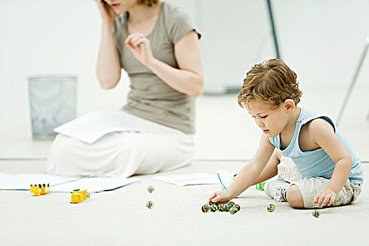 小男孩,坐,地面,玩,弹球,母亲,围绕,文件,背景
