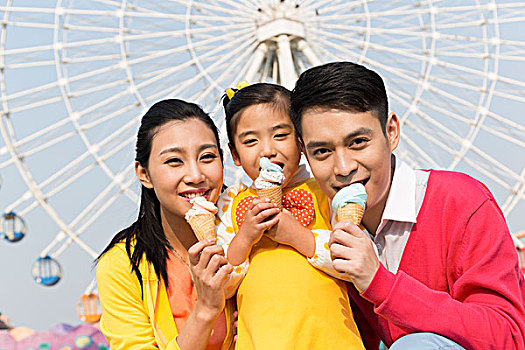 一家三口去游乐园玩吃冰淇淋