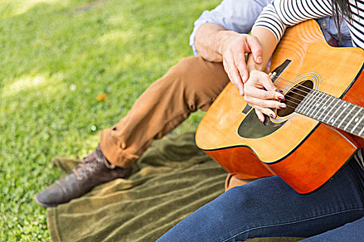 局部,风景,坐,夫妇,草地,演奏,木吉他