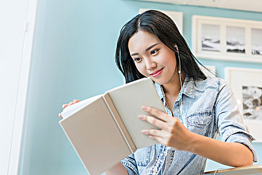 年輕女子邊看書邊聽音樂