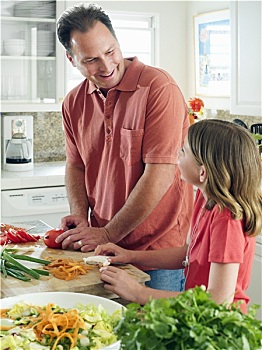 父亲,女儿,8-10岁,做饭,厨房操作台,男人,切,西红柿,微笑,侧面视角
