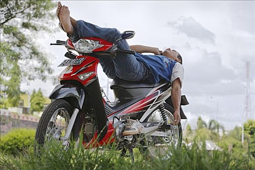 男青年,躺着,摩托车,移动,西部,加里曼丹,婆罗洲,印度尼西亚,亚洲