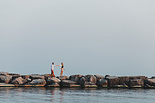远景,情侣,握手,漂石,墙壁,安大略湖,多伦多,加拿大