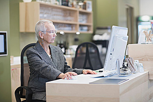 老年妇女,前台,台式电脑,酒店前台,书桌